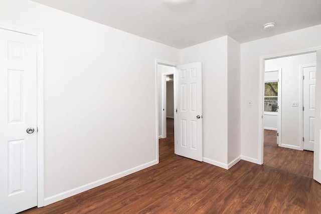 unfurnished bedroom with dark wood-type flooring