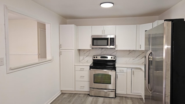 kitchen featuring light hardwood / wood-style floors, white cabinetry, backsplash, and appliances with stainless steel finishes