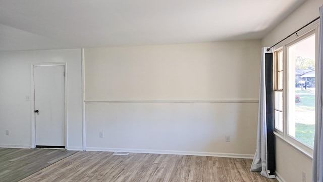 empty room with a wealth of natural light and light wood-type flooring