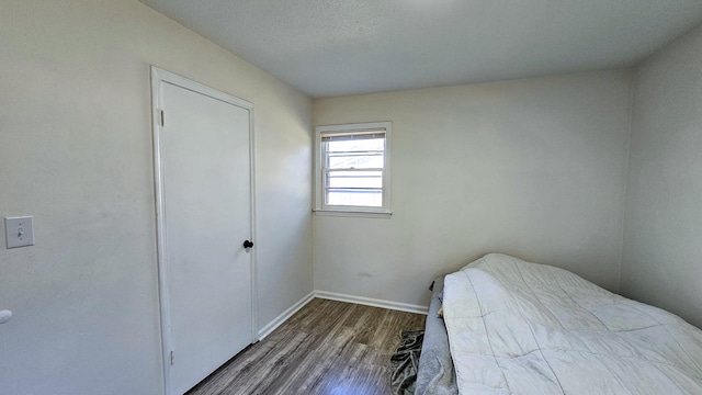 unfurnished bedroom with a textured ceiling and dark hardwood / wood-style floors