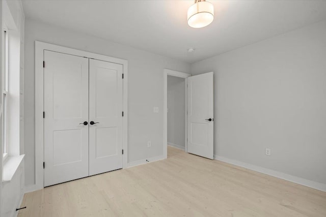 unfurnished bedroom with a closet and light hardwood / wood-style flooring