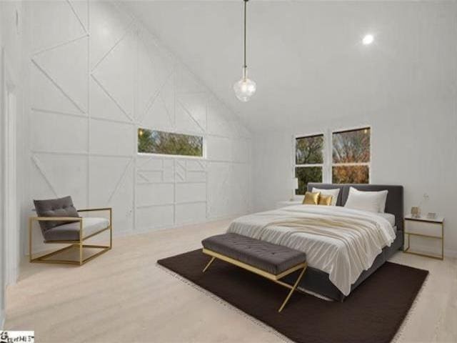 bedroom with hardwood / wood-style floors and a towering ceiling