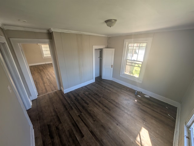 unfurnished bedroom with a closet, dark wood-type flooring, and ornamental molding