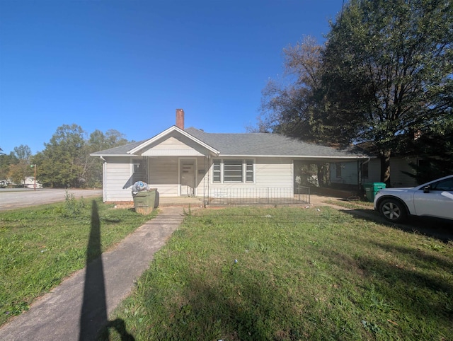 view of front facade featuring a carport, covered porch, and a front yard