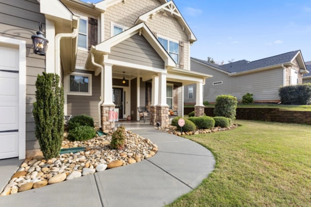 view of front of property featuring a porch, a garage, and a front yard