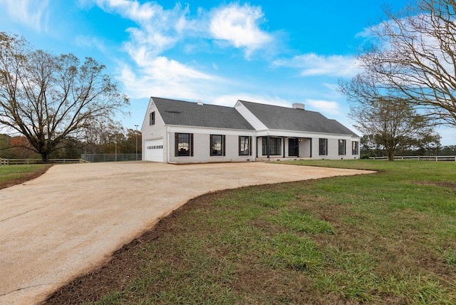 rear view of property featuring a lawn and a garage