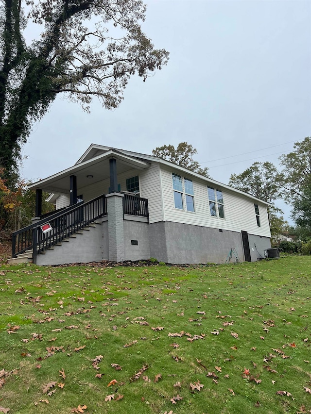 view of side of home featuring a yard and cooling unit