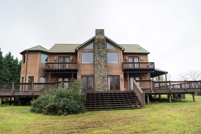 back of property with a lawn, a balcony, and a wooden deck