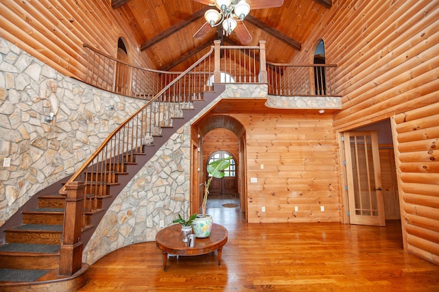 stairway with beam ceiling, wood-type flooring, wood ceiling, and high vaulted ceiling