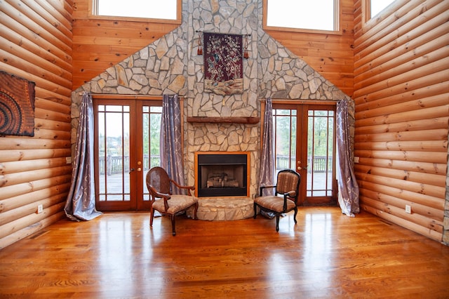 living area featuring hardwood / wood-style flooring, a towering ceiling, and french doors