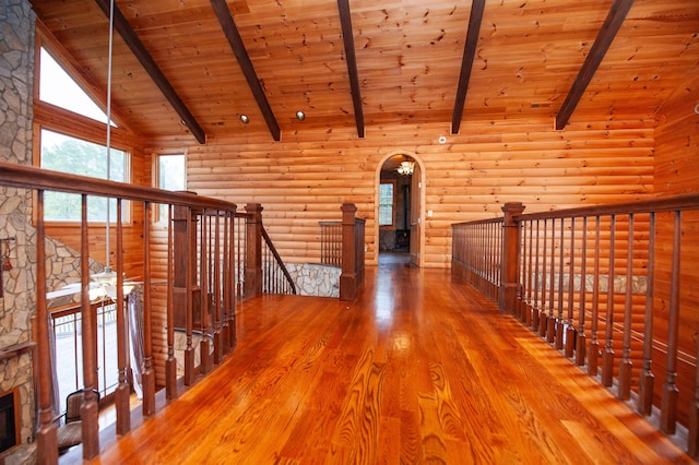 corridor featuring log walls, beamed ceiling, wood-type flooring, and high vaulted ceiling