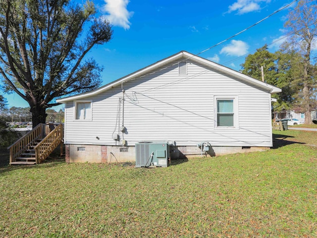 view of home's exterior with central AC unit and a yard