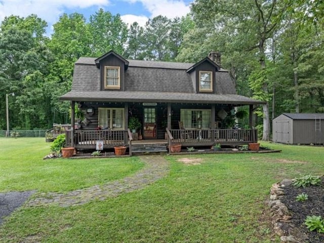 view of front of house with a front yard, a porch, and a storage shed