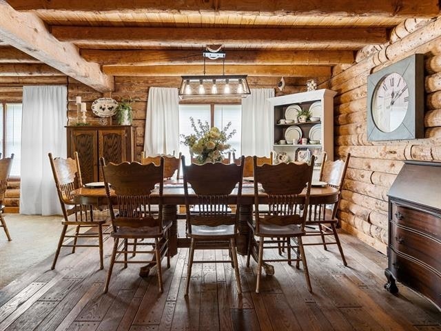 dining space featuring beam ceiling, wood ceiling, and hardwood / wood-style flooring