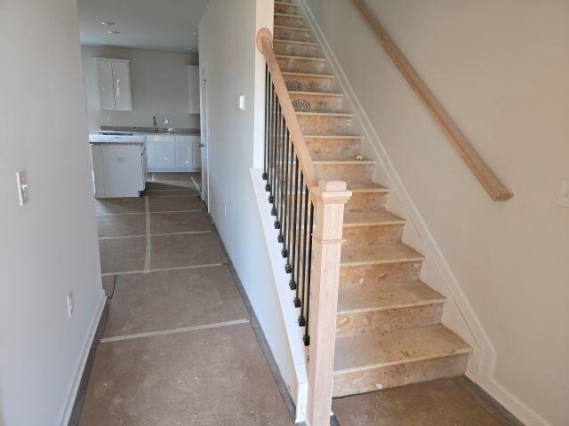 stairs featuring concrete flooring