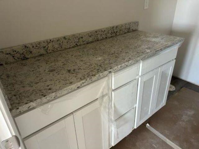 interior details with white cabinets and light stone countertops