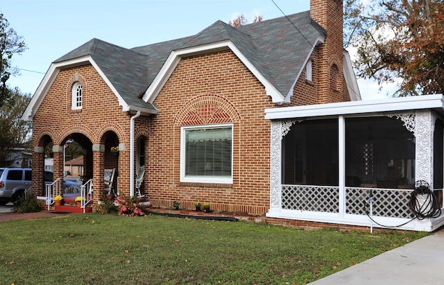 english style home with a front lawn and a sunroom