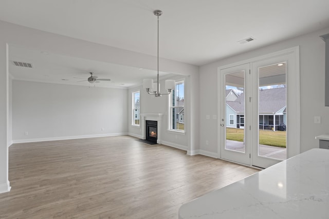 living room with hardwood / wood-style flooring, plenty of natural light, and ceiling fan with notable chandelier