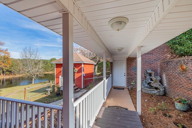 view of patio with a water view and a storage unit