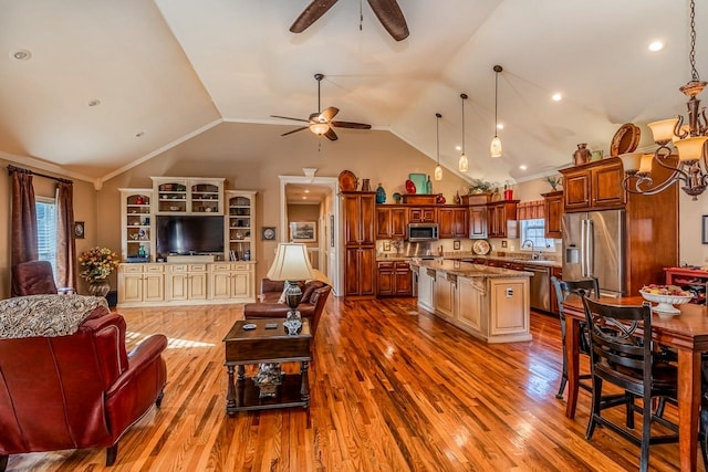 living room featuring plenty of natural light, lofted ceiling, and light hardwood / wood-style flooring