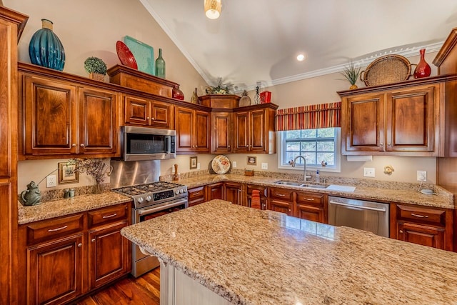 kitchen featuring light stone countertops, sink, appliances with stainless steel finishes, and ornamental molding