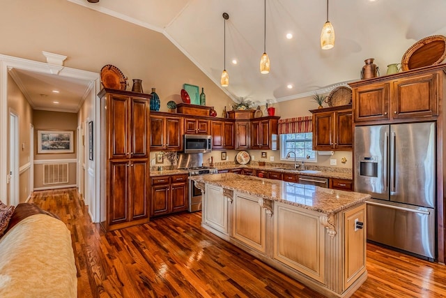 kitchen featuring pendant lighting, a center island, lofted ceiling, sink, and appliances with stainless steel finishes