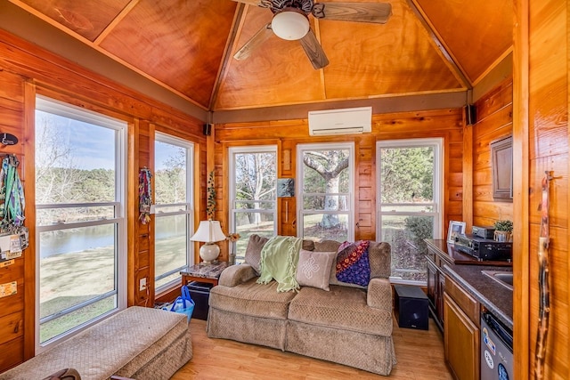 sunroom / solarium featuring a wall mounted air conditioner, a healthy amount of sunlight, and lofted ceiling