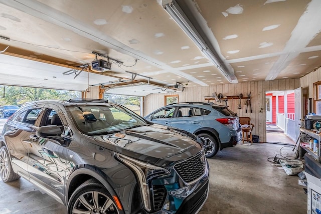 garage featuring wood walls and a garage door opener