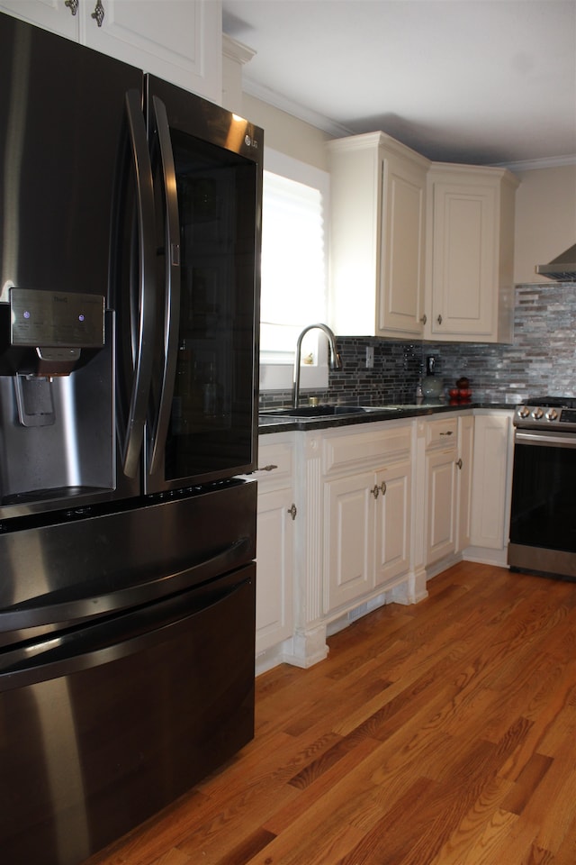 kitchen featuring white cabinetry, electric stove, black fridge, and light hardwood / wood-style floors