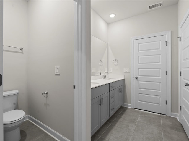 bathroom featuring vanity, tile patterned floors, and toilet