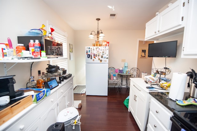 kitchen featuring dark wood-type flooring, white cabinetry, hanging light fixtures, stove, and white fridge