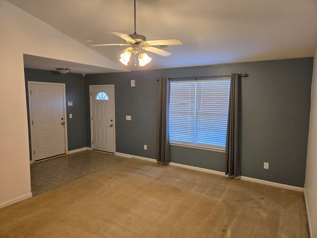 foyer with ceiling fan, lofted ceiling, and light carpet