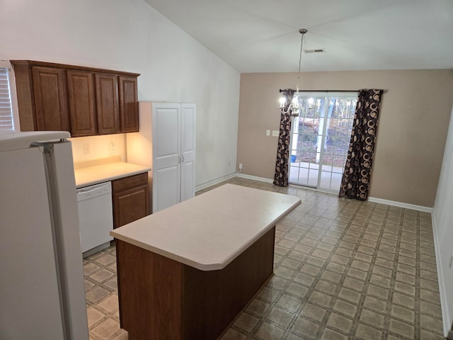 kitchen featuring white appliances, pendant lighting, a chandelier, a kitchen island, and lofted ceiling