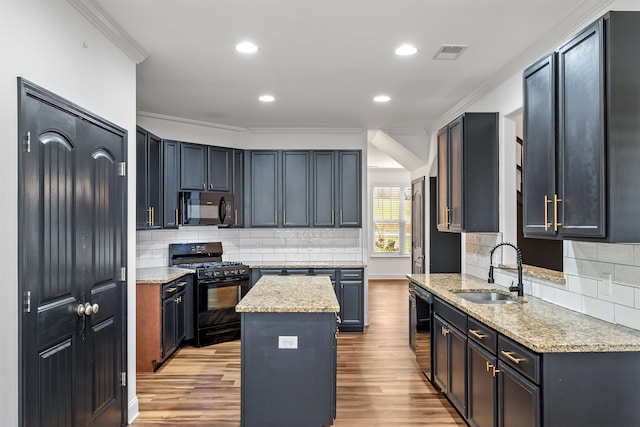 kitchen with light stone countertops, sink, light hardwood / wood-style flooring, a kitchen island, and black appliances