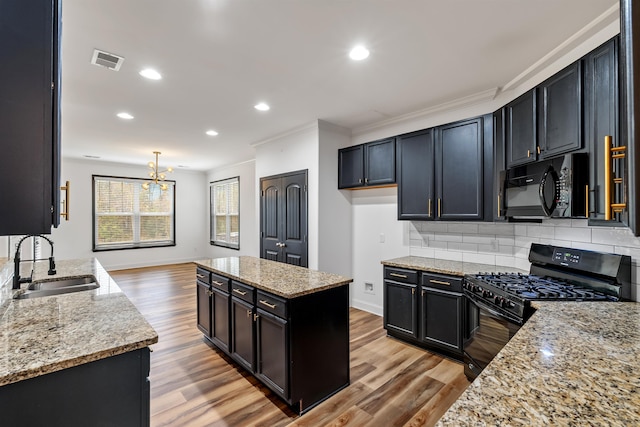 kitchen with crown molding, light stone counters, sink, and black appliances