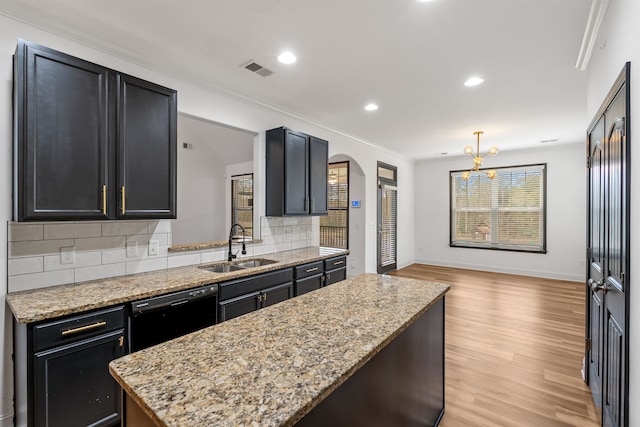 kitchen featuring light stone countertops, dishwasher, sink, light hardwood / wood-style flooring, and decorative backsplash