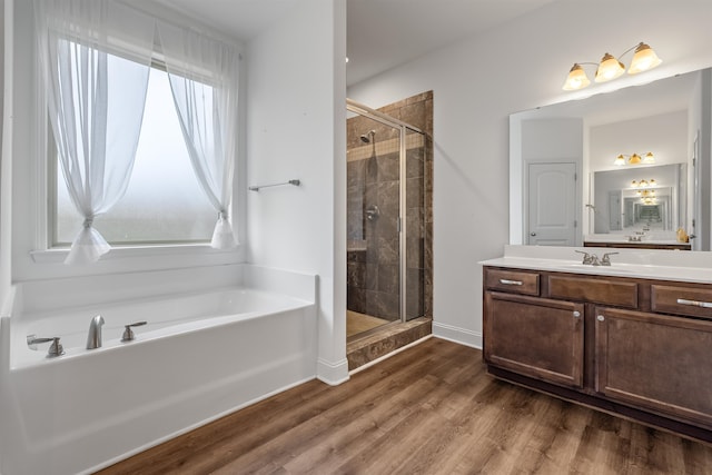 bathroom with vanity, hardwood / wood-style floors, and plus walk in shower