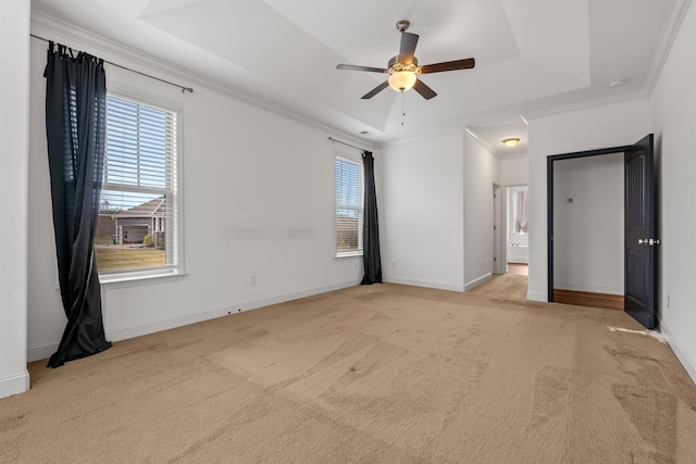 unfurnished bedroom featuring light carpet, a tray ceiling, ceiling fan, and ornamental molding