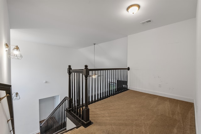 staircase featuring carpet