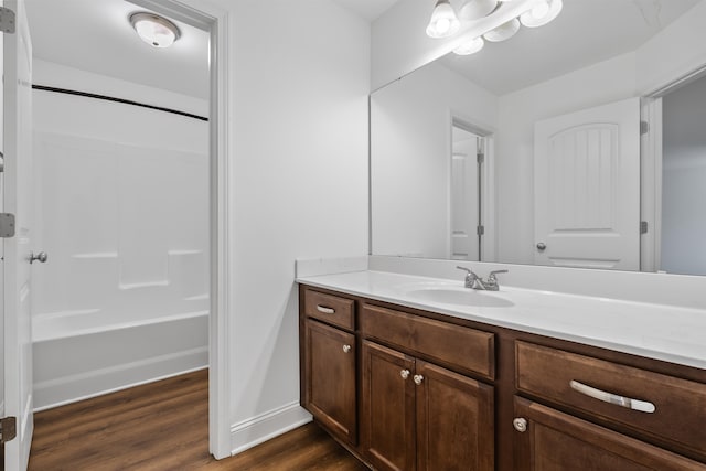 bathroom with hardwood / wood-style flooring, vanity, and shower / bathtub combination