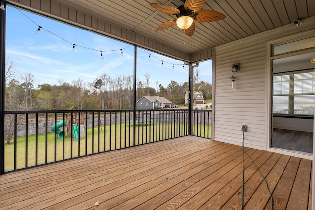 deck with a playground, ceiling fan, and a yard