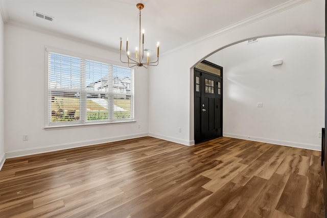 unfurnished dining area featuring hardwood / wood-style flooring, ornamental molding, and an inviting chandelier