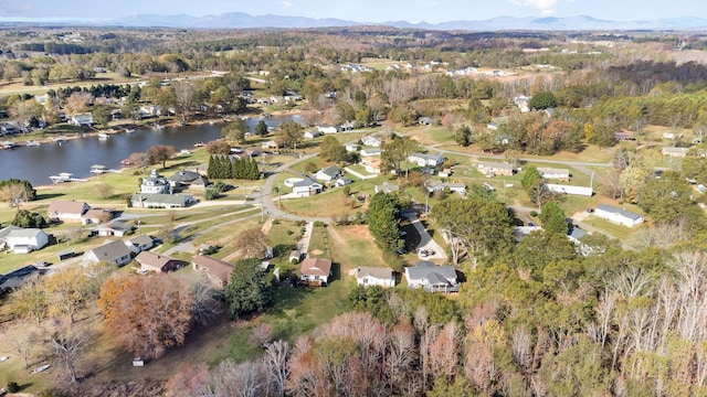 birds eye view of property with a water and mountain view and a view of trees