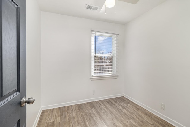 empty room featuring a ceiling fan, light wood-type flooring, visible vents, and baseboards