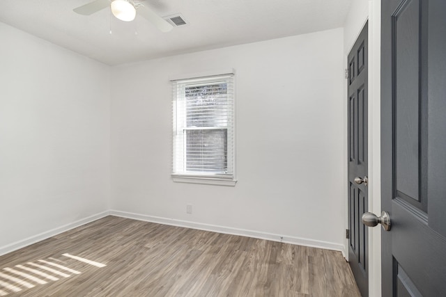 unfurnished room featuring light wood-style flooring, visible vents, ceiling fan, and baseboards