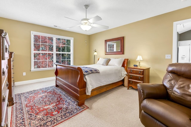 carpeted bedroom with ceiling fan and white refrigerator with ice dispenser