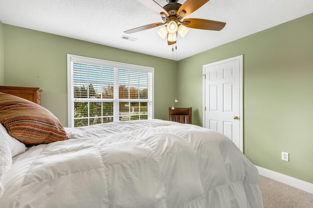 bedroom with carpet flooring, ceiling fan, and a textured ceiling