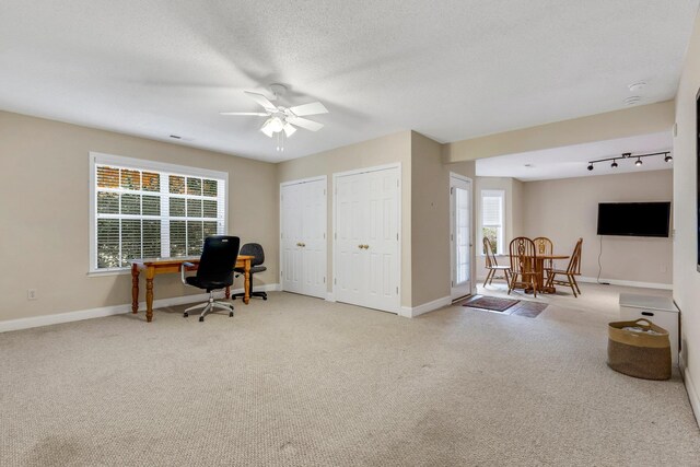 carpeted home office with ceiling fan and a textured ceiling