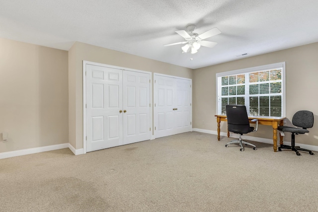 carpeted office featuring a textured ceiling and ceiling fan