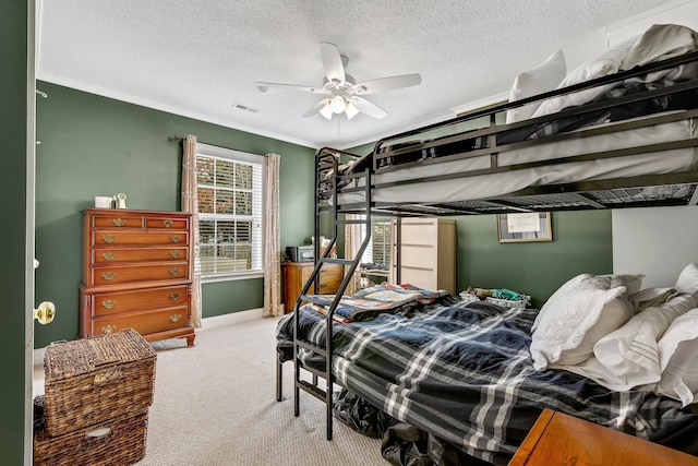 bedroom with ceiling fan, crown molding, carpet floors, and a textured ceiling